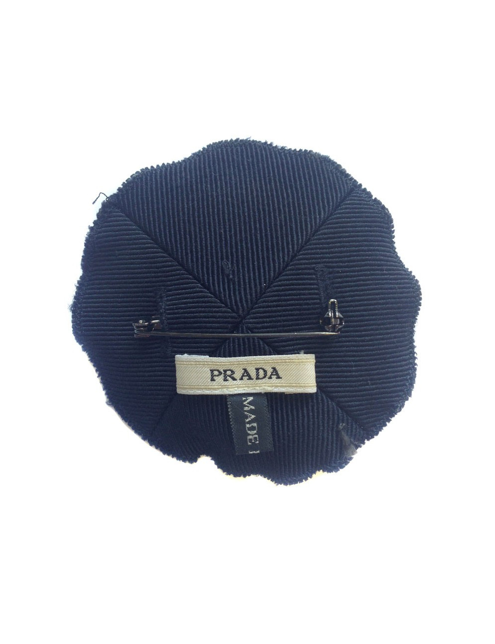 Broche PRADA brodée sur fond bleu marine