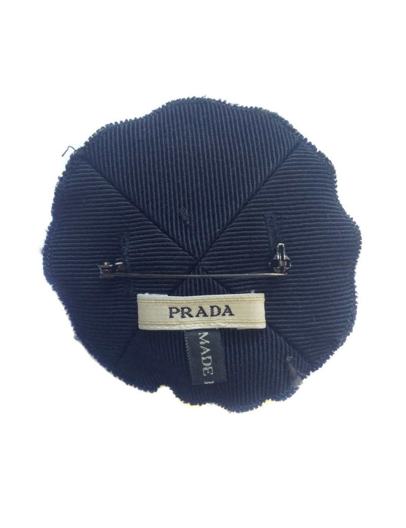 Broche PRADA brodée sur fond bleu marine