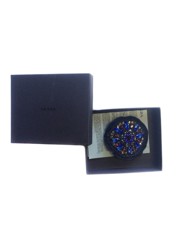 Broche PRADA brodée sur fond bleu marine