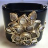 CHANEL cuff in black resin and flower in gold metal and transparent resin