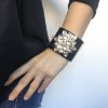 CHANEL cuff in black resin and flower in gold metal and transparent resin