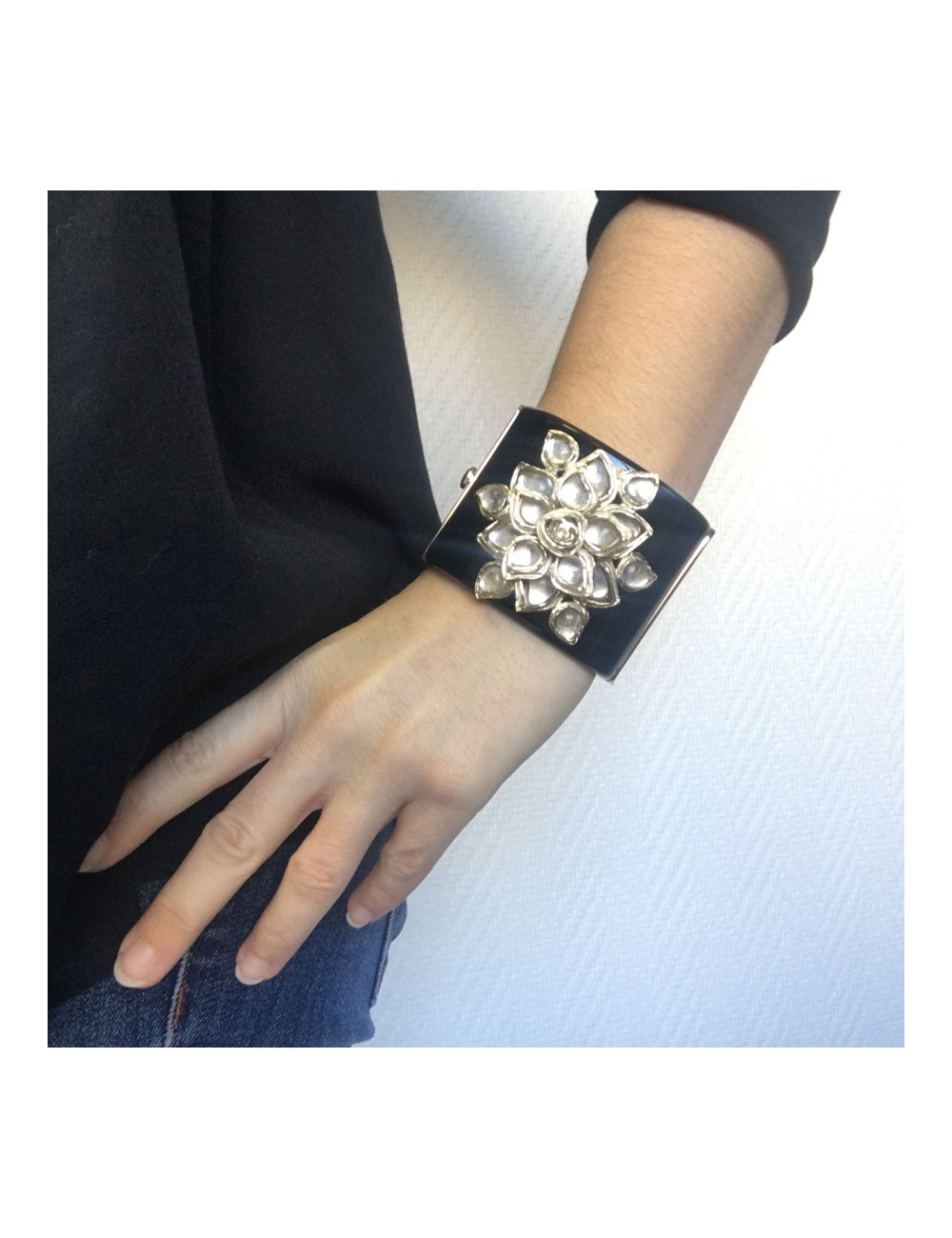 Manchette CHANEL en résine noire et fleur en métal doré et résine transparente