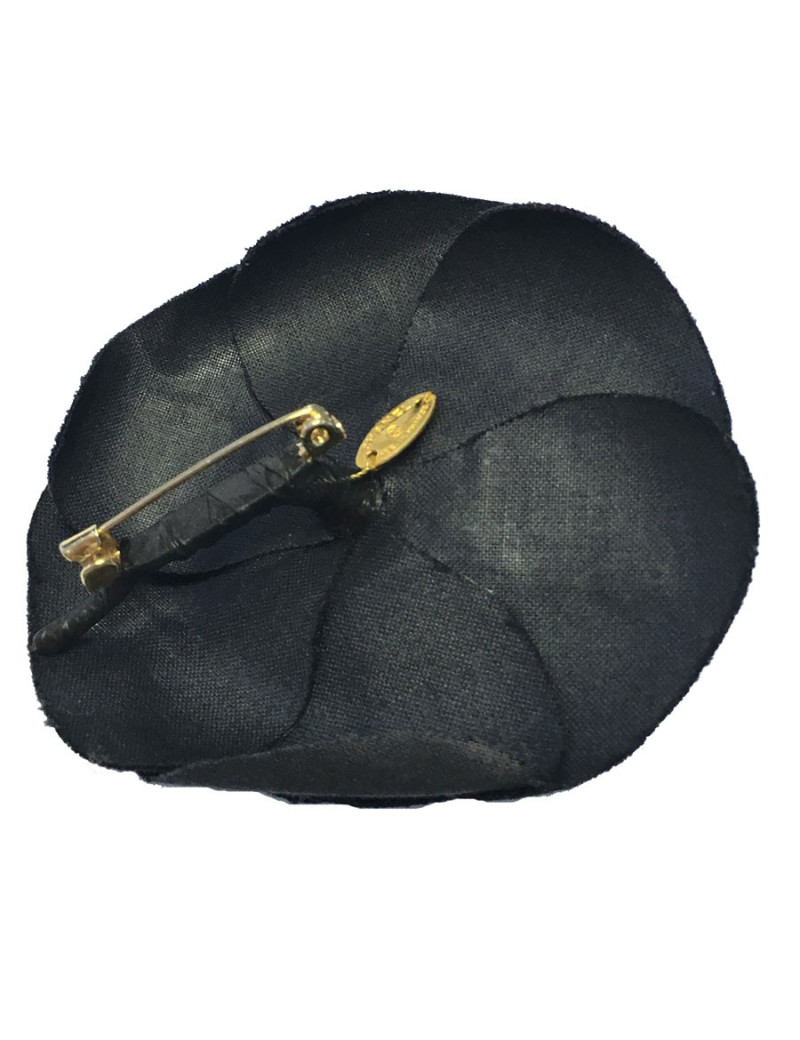 In black silk CHANEL Camellia brooch