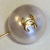 Epingle CHANEL en métal doré et demi perle nacrée