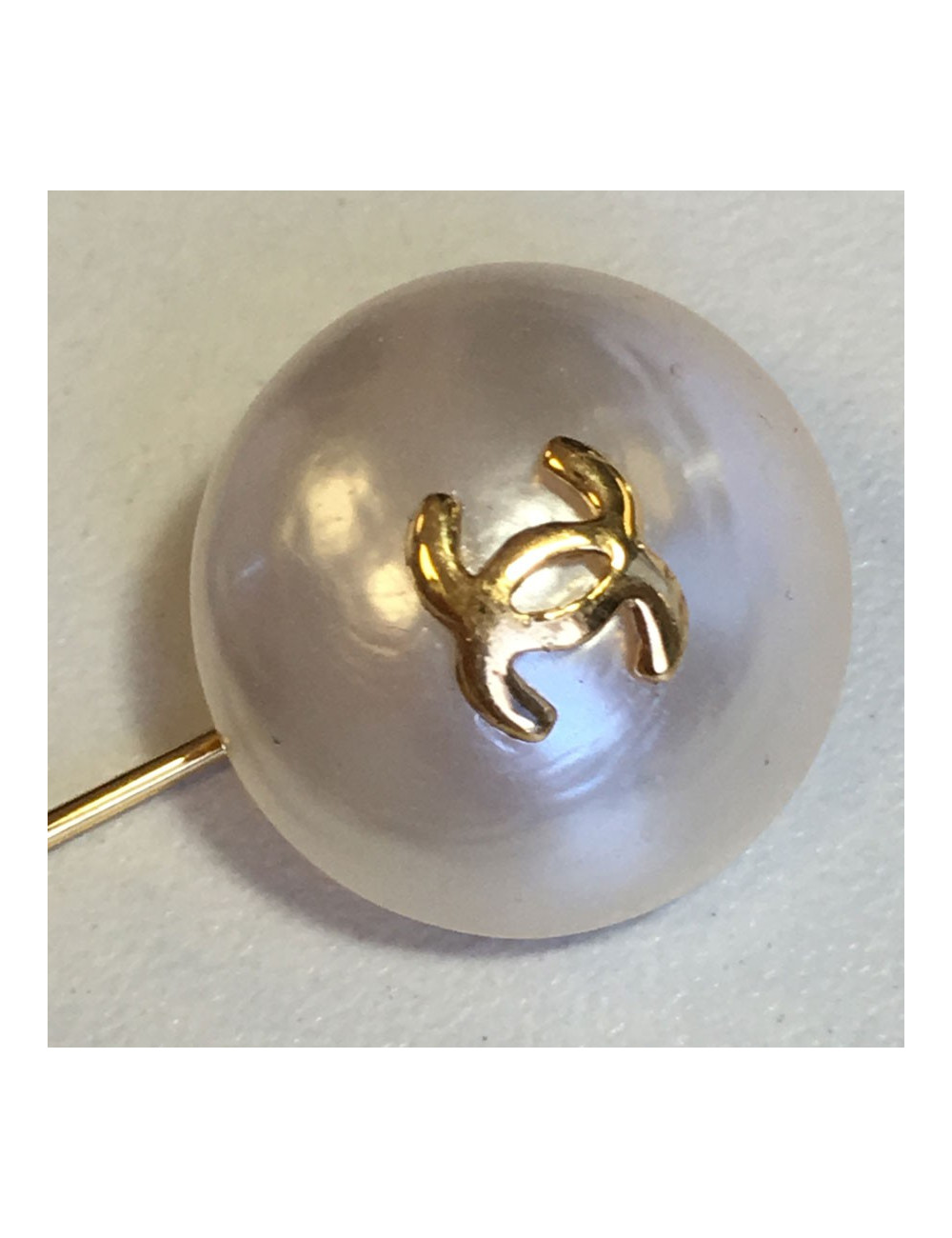 Epingle CHANEL en métal doré et demi perle nacrée