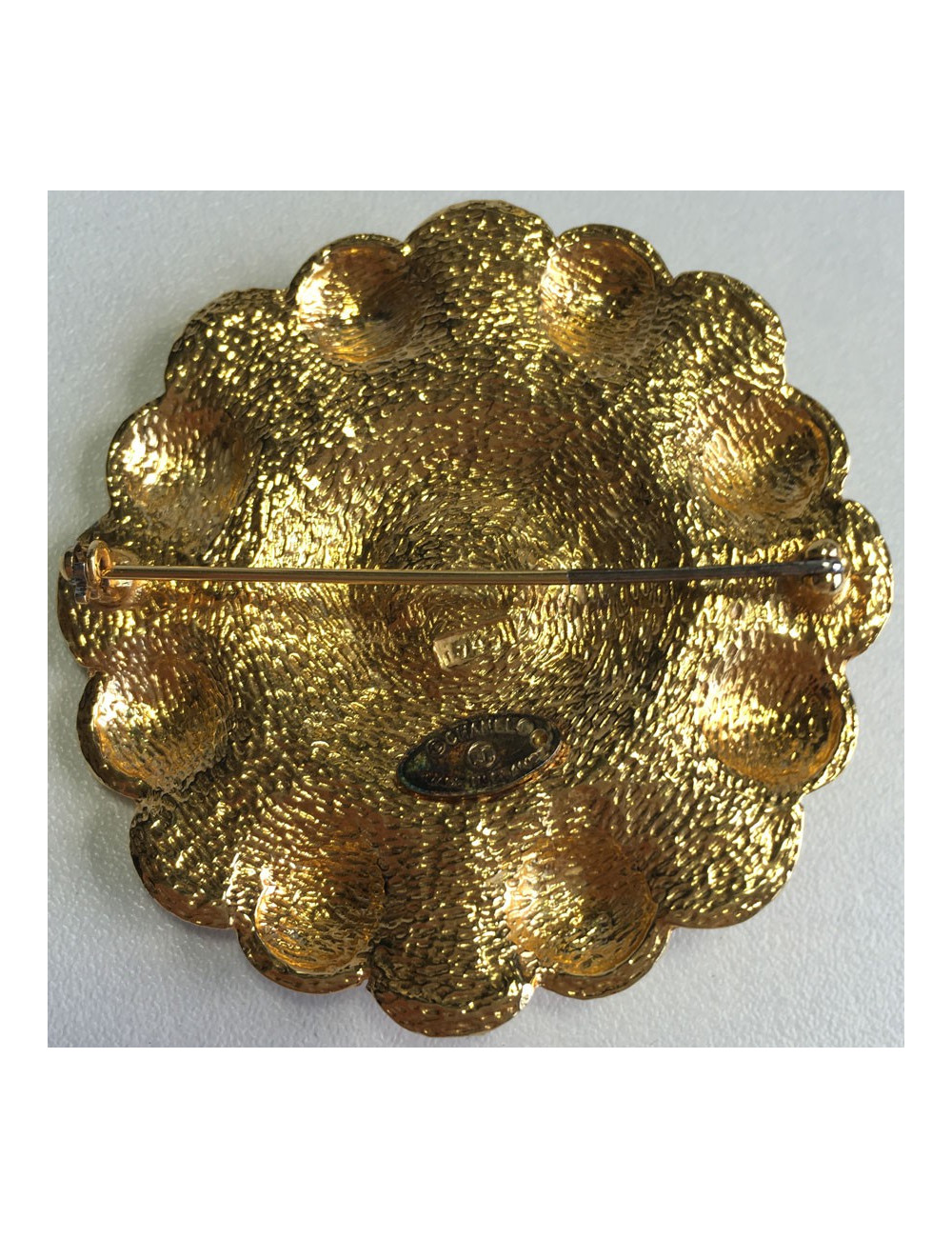 Broche CHANEL ronde en métal doré et centre en résine noire