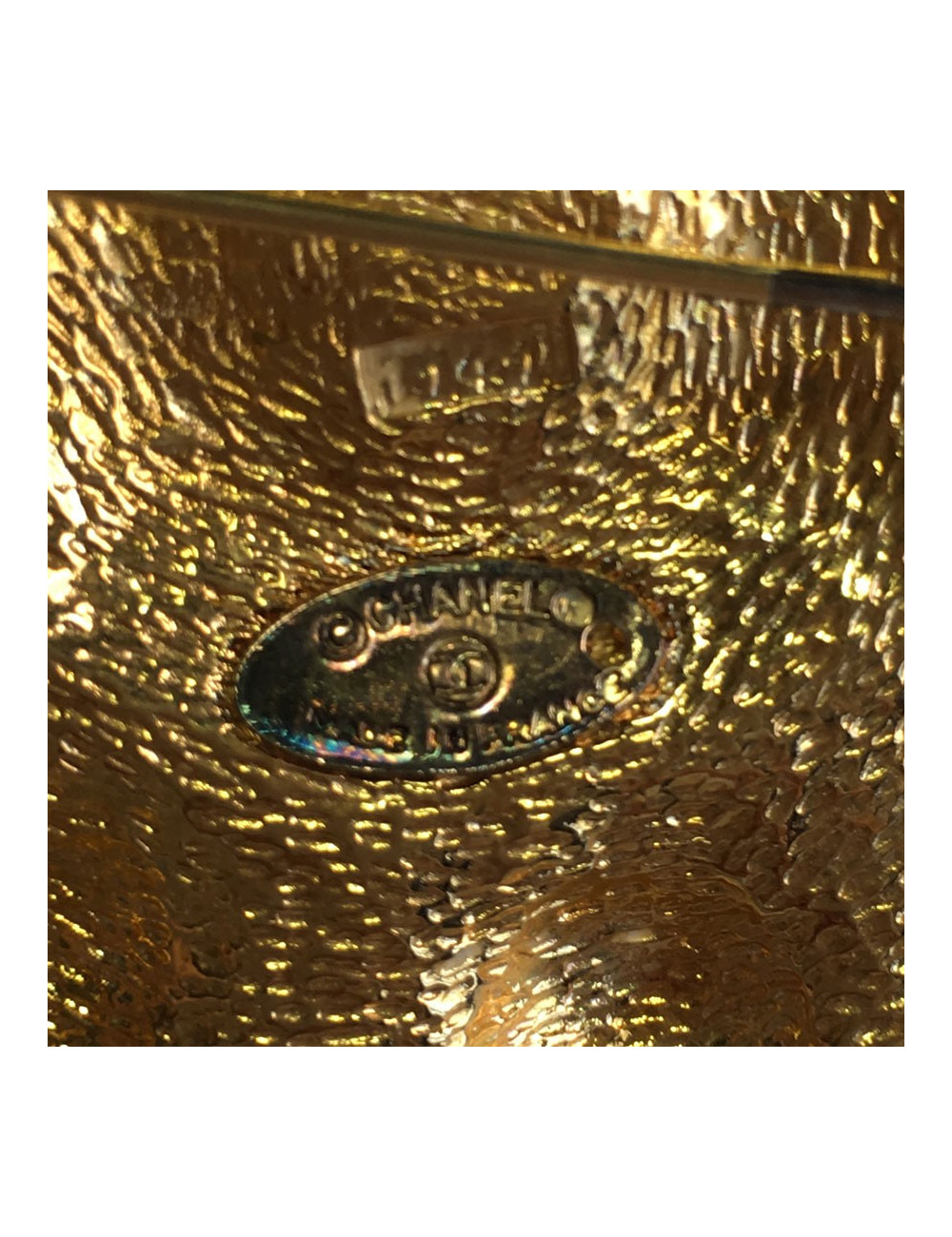 Broche CHANEL ronde en métal doré et centre en résine noire