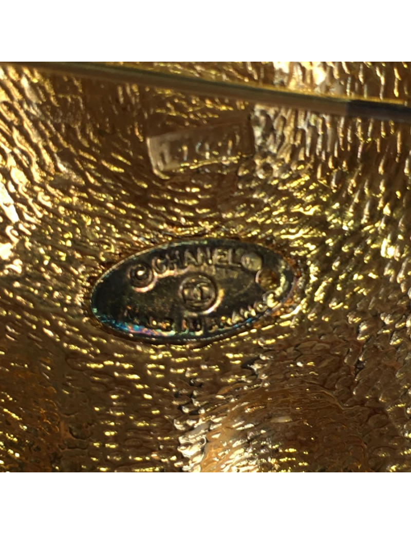 Broche CHANEL ronde en métal doré et centre en résine noire