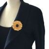 Pin round CHANEL in gold metal and Center in black resin