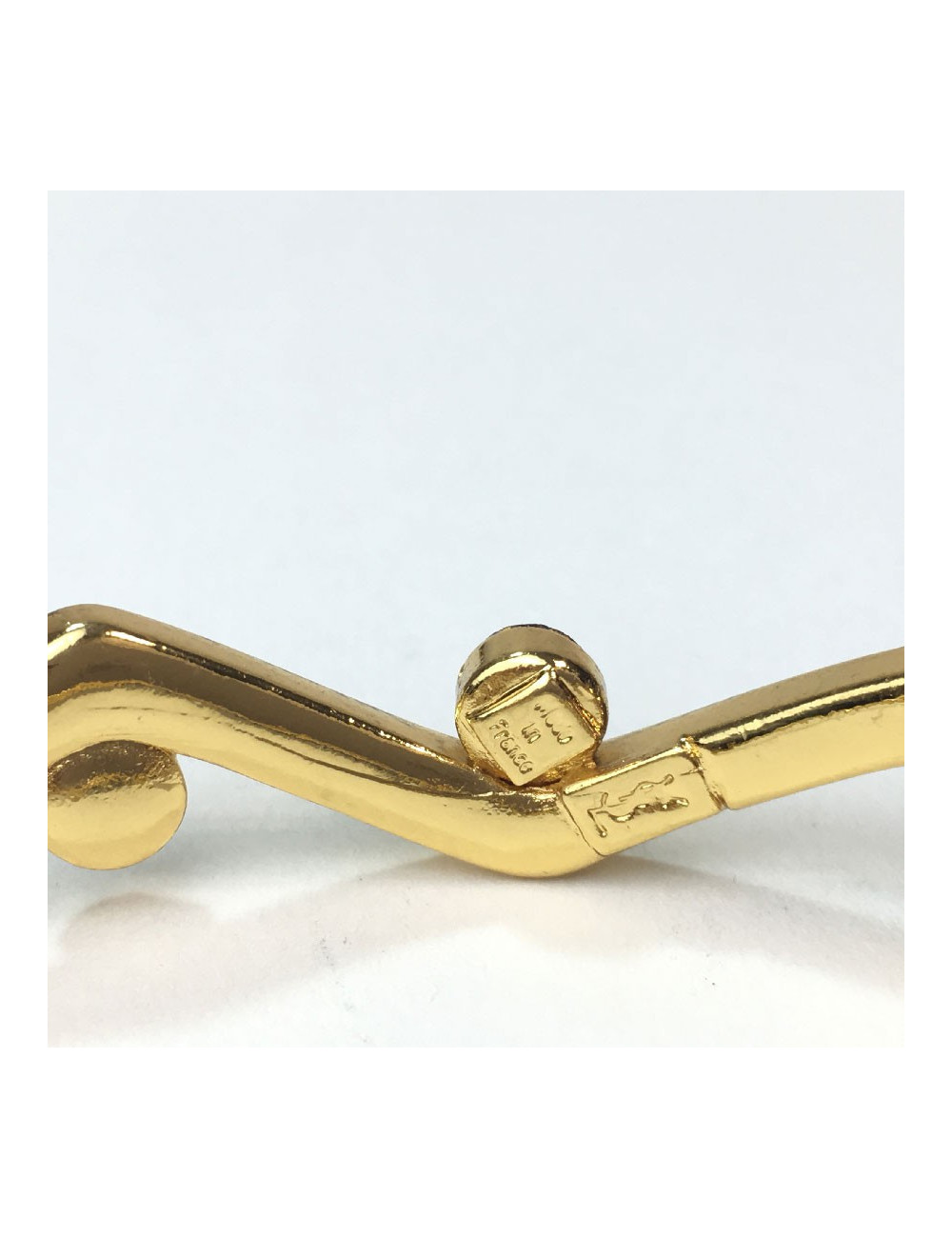 Bracelet rigide YVES SAINT LAURENT métal doré et strass rubis et améthyste