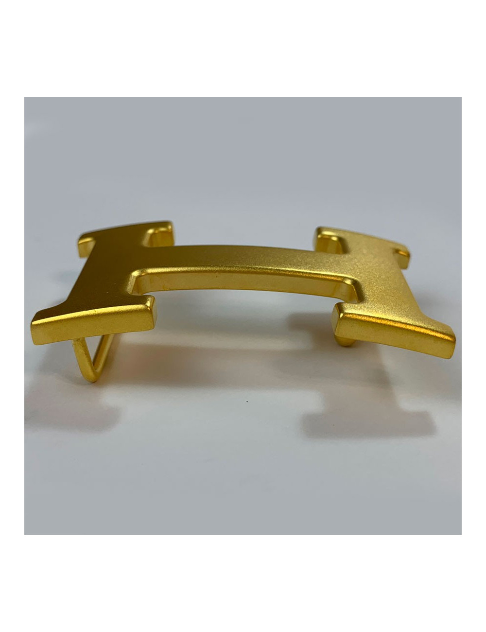 Boucle H HERMES en métal doré mat